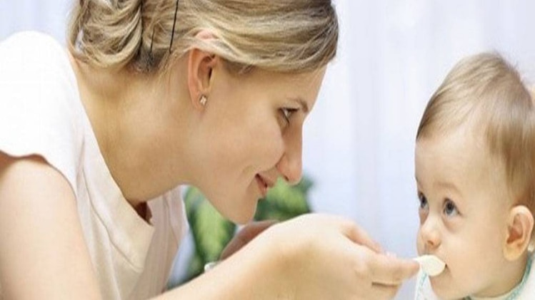 बच्चे को खाना ख‍िलाती मां 