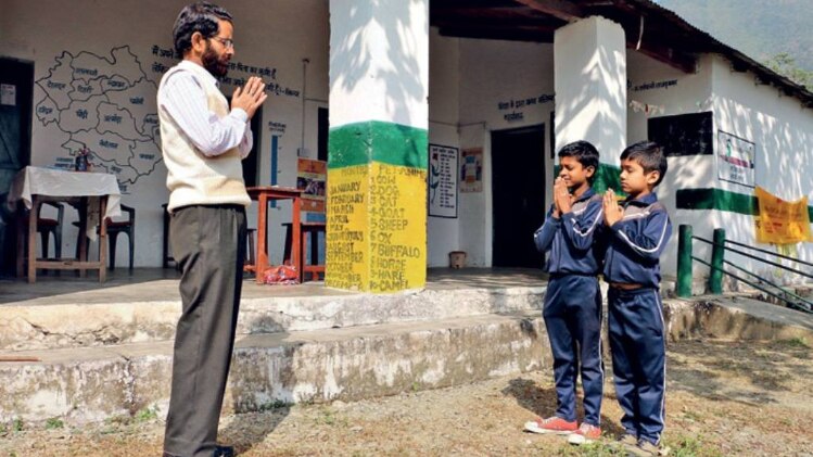 पौड़ी के पयाल गांव के स्कूल में प्रार्थना करते दो छात्र और शिक्षक