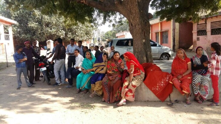 किसान की मौत के बाद घर के बाहर बैठीं गमजदा महिलाएं