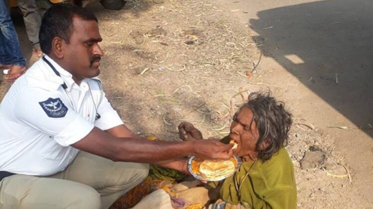 बी गोपाल महिला को खाना खिलाते हुए
