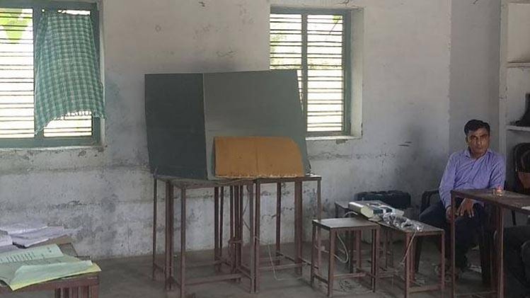 बूथ के अंदर खिड़की पर टांगा गया गीला कपड़ा