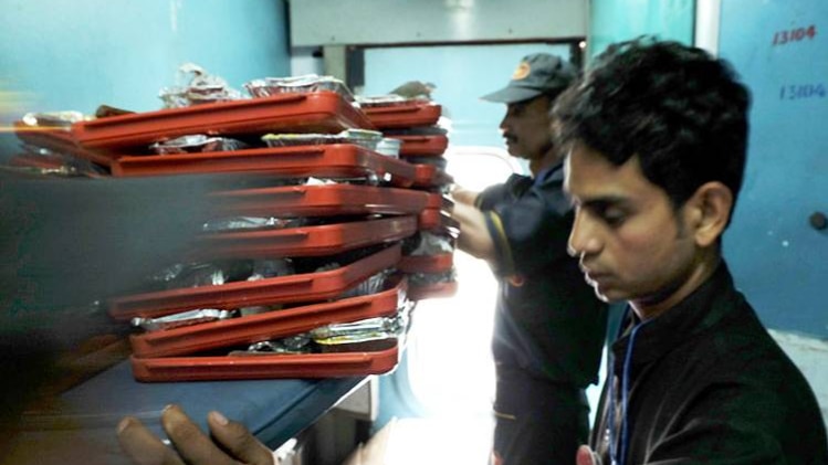 ट्रेन में खाना देते कर्मचारी (Getty Images)