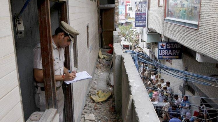 घर पर तफ्तीश करते पुलिसकर्मी