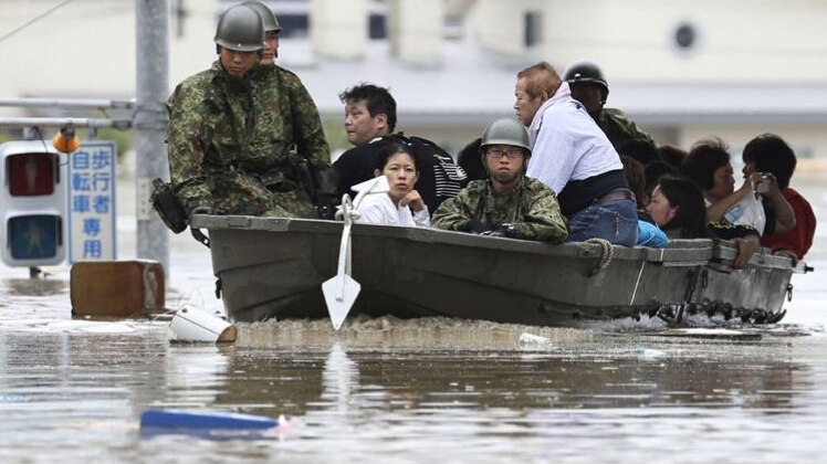 जापान में बाढ़ के बीच लोगों को बाहर निकालते जवान