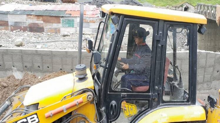 खराब मौसम के बीच जेसीबी मशीन चला रही लड़कियां
