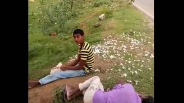 शराब के नशे में मुर्गे का पंख उधेड़ता युवक