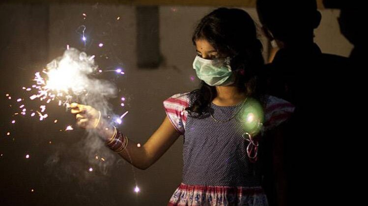 मास्क लगाकर दीपावली मनाती लड़की (फाइल फोटो-AP)
