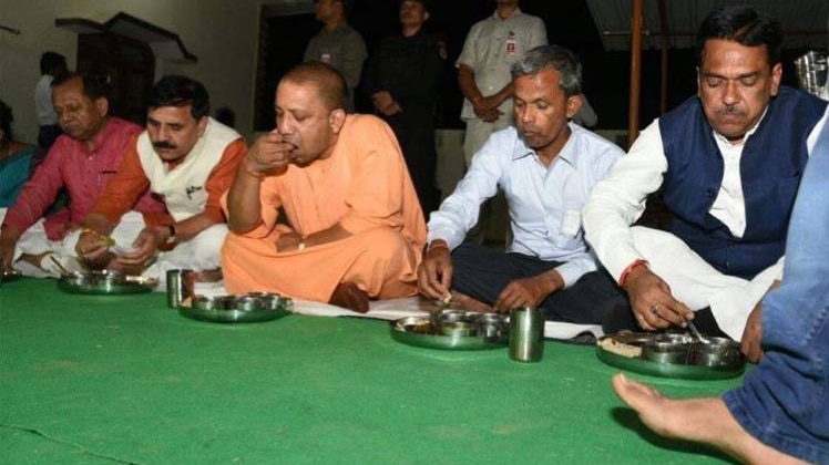दलित के घर भोजन करते सीएम योगी आदित्यनाथ (फोटो-फाइल)