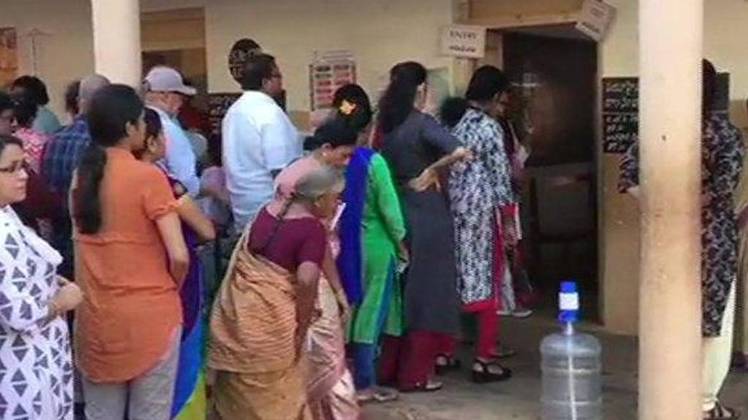 पोलिंग बूथ पर मतदान के लिए खड़े लोग (ANI)