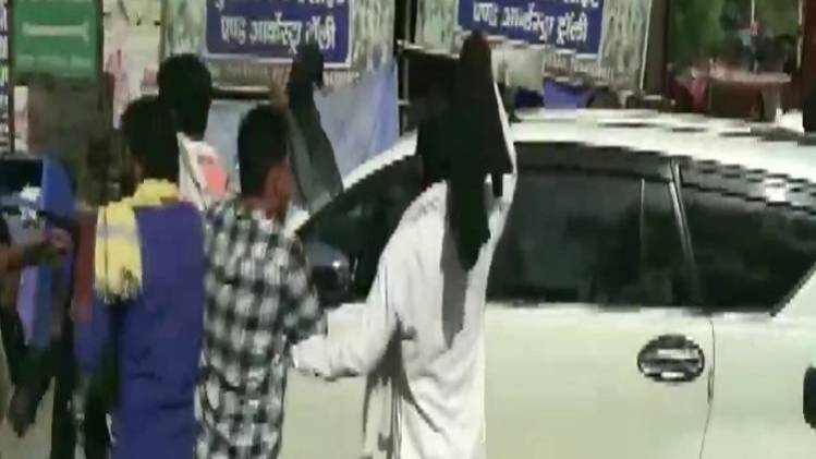 कार का घेराव करते प्रदर्शनकारी