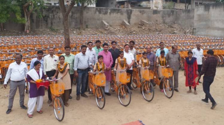 बीजेपी सरकार द्वारा बांटी गईं भगवा रंग की साइकिलें