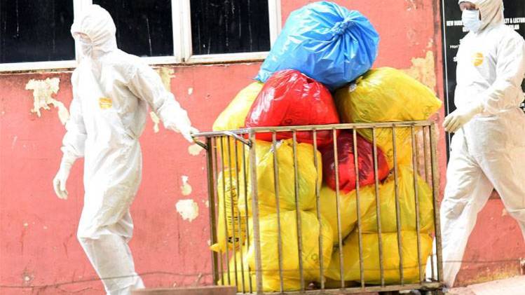 बॉयोमेडिकल अपशिष्ट ले जाते कर्मचारी