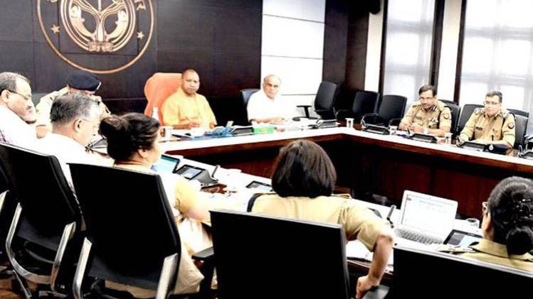 पुलिस अधिकारियों के साथ बैठक करते सीएम योगी आदित्यनाथ