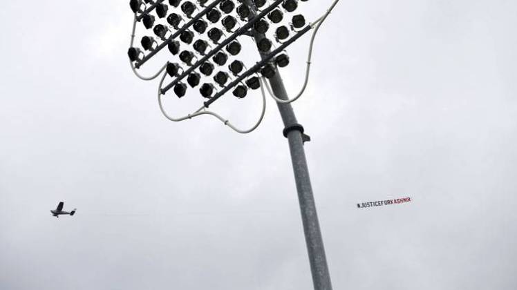 An aircraft flies past carrying a banner (AP)