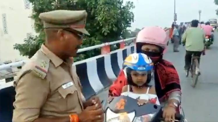 बच्ची के साथ हेलमेट पहने महिला