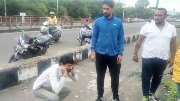 एक व्यक्ति से उठक-बैठक लगवाते निगम दस्ते के लोग ( फोटोः रवीश पाल सिंह)