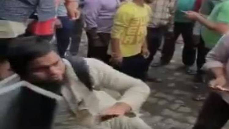 वीडियो में भरे बाज़ार एक आदमी को बड़ी बेरहमी से पीटा जा रहा है