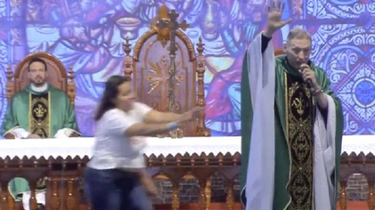 पादरी को धक्का देती महिला