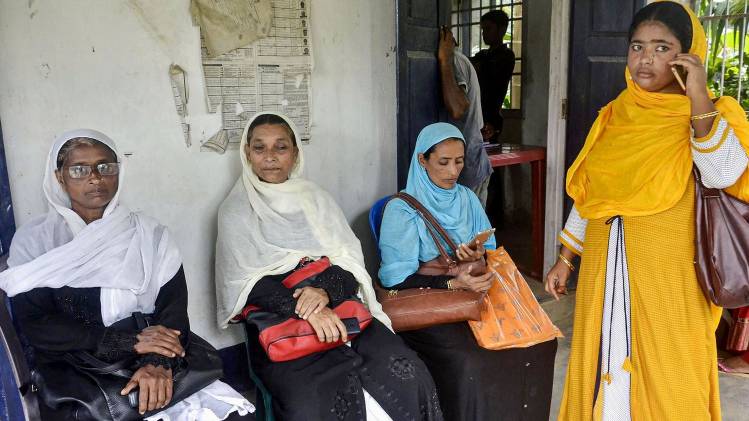 लिस्ट में नाम चेक करने के लिए बैठीं महिलाएं (फाइल फोटो- PTI)