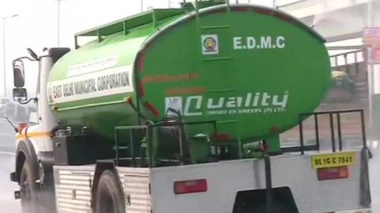 आनंद विहार में पानी का छिड़काव कराती EDMC (ANI)