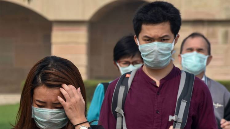 दिल्ली में एंटी-पॉल्यूशन मास्क पहने विदेशी पर्यटक (फोटो-PTI) 