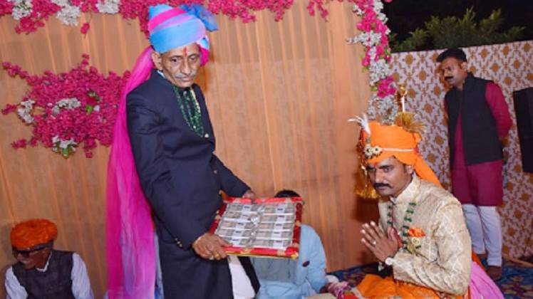 दूल्हे को दहेज के रुपये से भरी थाल देने की कोशिश करते ससुर
