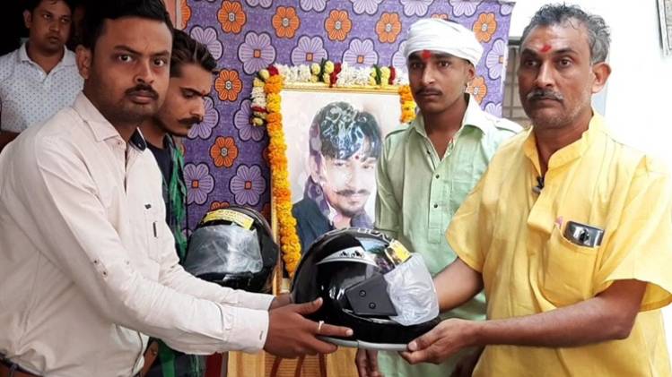 तेरहवीं में युवाओं को हेलमेट बांटते पिता महेंद्र दीक्षित 