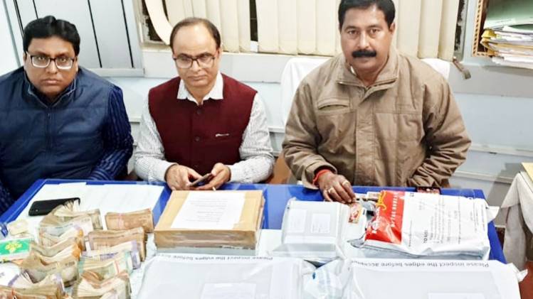 बरामद जेवरात और नकदी के साथ अधिकारी