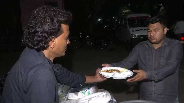 दिल्ली में परिजनों को खिला रहा शख्स (फोटो: ANI)