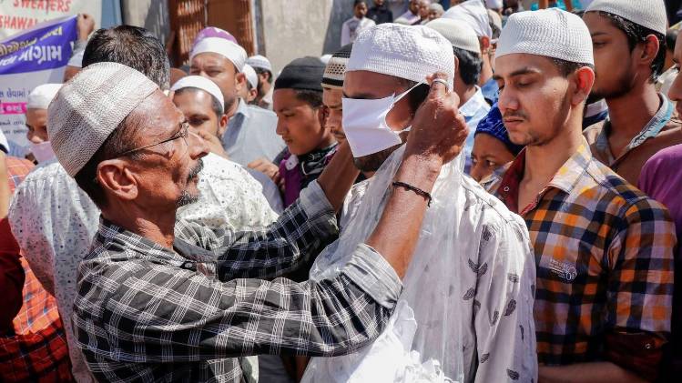 अहमदाबाद में युवाओं के बीच मास्क बांटा जा रहा है. (फोटो- पीटीआई)