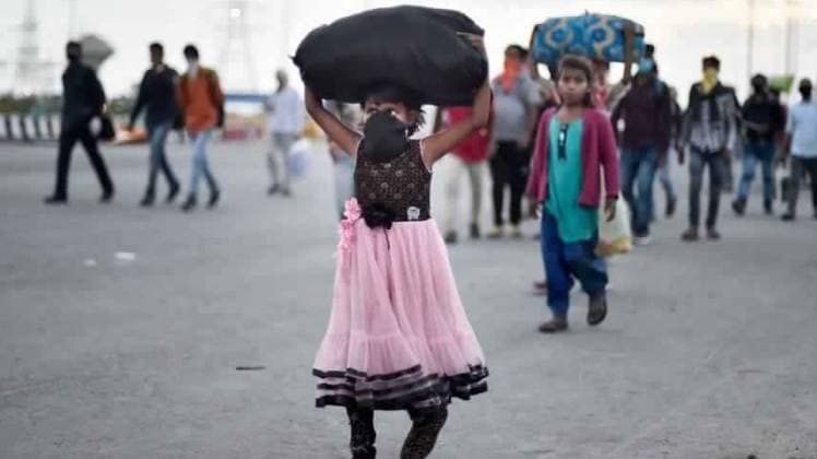 एन एच-24 पर अपने परिवार के साथ घर की ओर जाती बच्ची (फोटो- पीटीआई)