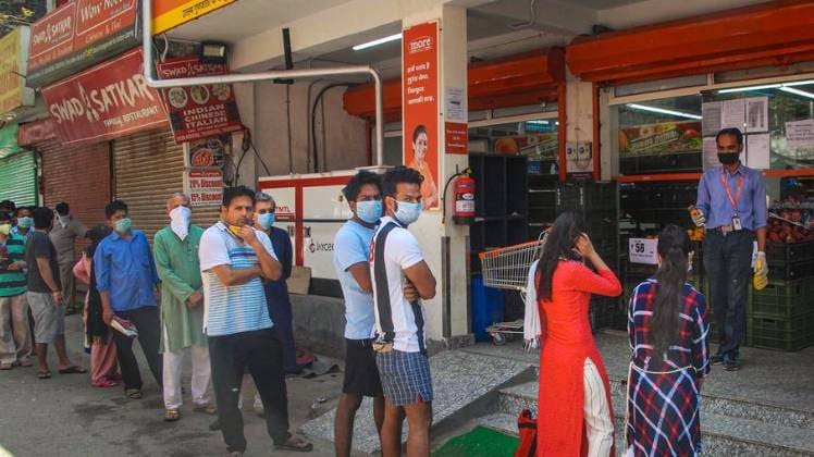 नोएडा में सामान खरीदने के लिए कतार में लगे लोग (फोटो- पीटीआई)