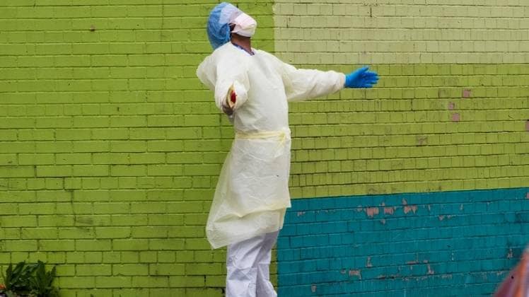 इमरजेंसी रूम से बाहर आकर कुछ देर राहत की सांस लेता एक मेडिकलकर्मी (फोटो: PTI, न्यूयॉर्क)