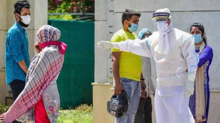 दिल्ली में एक शख्स को चेक करने के लिए जाता स्वास्थ्यकर्मी (फोटो- पीटीआई)