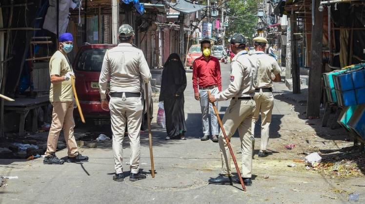 दिल्ली के जहांगीरपुरी इलाके में लोगों को बाहर निकलने से रोकती पुलिस (फोटो- पीटीआई)