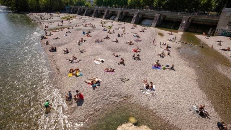 जर्मनी में म्यूनिख शहर में सन बाथ के साथ-साथ सोशल डिस्टेंसिंग (फोटो-पीटीआई)