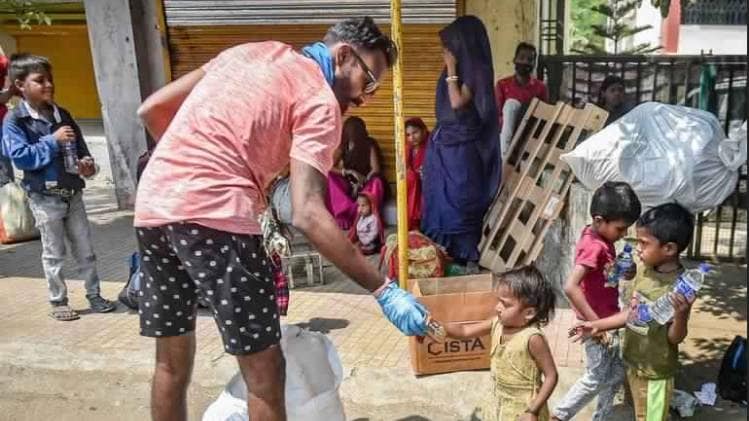 पालघर में लॉकडाउन में फंसे लोगों की मदद करता एक शख्स (फोटो- पीटीआई)