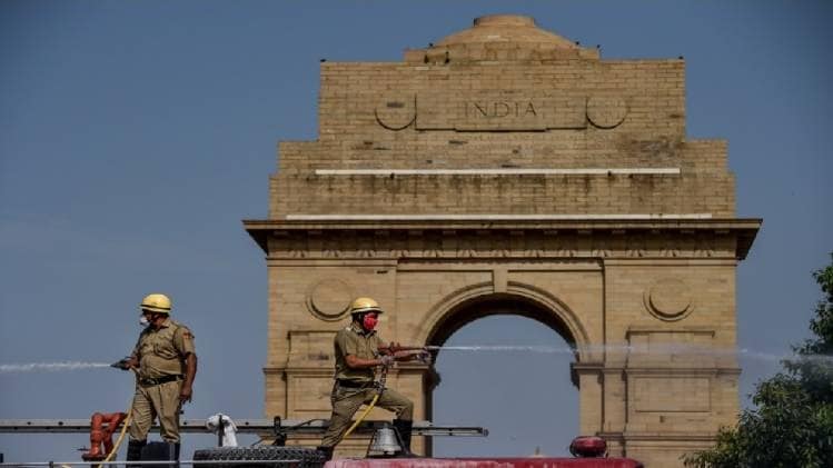 इंडिया गेट के पास के इलाके को सैनेटाइज करते पुलिसकर्मी (तस्वीर- पीटीआई)