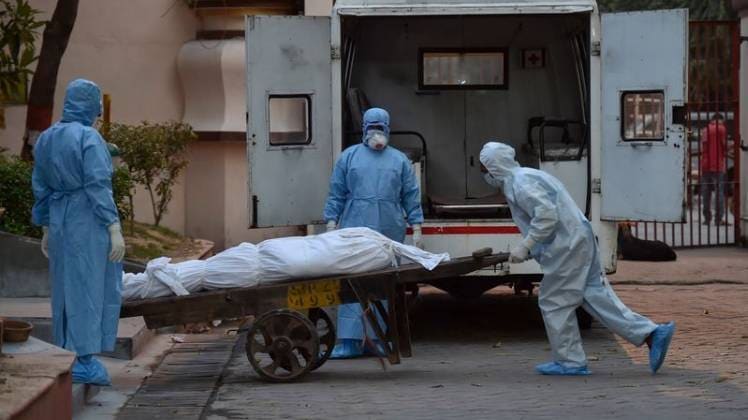 दिल्ली में एक डेड बॉडी को अंतिम संस्कार के लिए ले जाते सरकारी कर्मचारी (फोटो- पीटीआई)