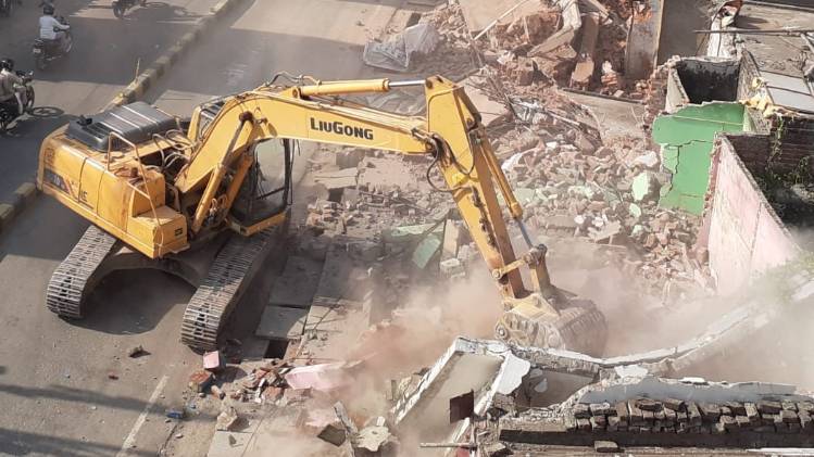 दुकानों को तोड़ते बुल्डोजर