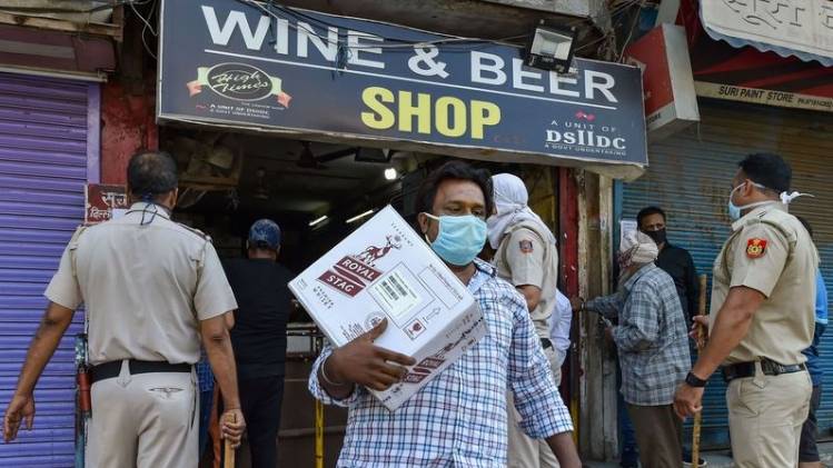 दिल्ली में शराब खरीदकर निकलता एक शख्स (फोटो- पीटीआई)