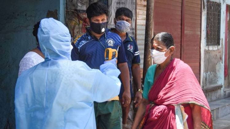 मुंबई के धारावी में लोगों का तापमान चेक करते स्वास्थ्यकर्मी (फोटो- पीटीआई)