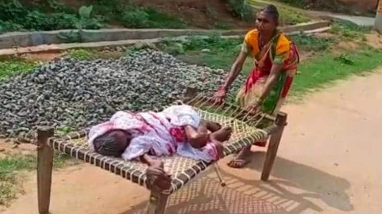 मां को चारपाई पर ले जाती बेटी