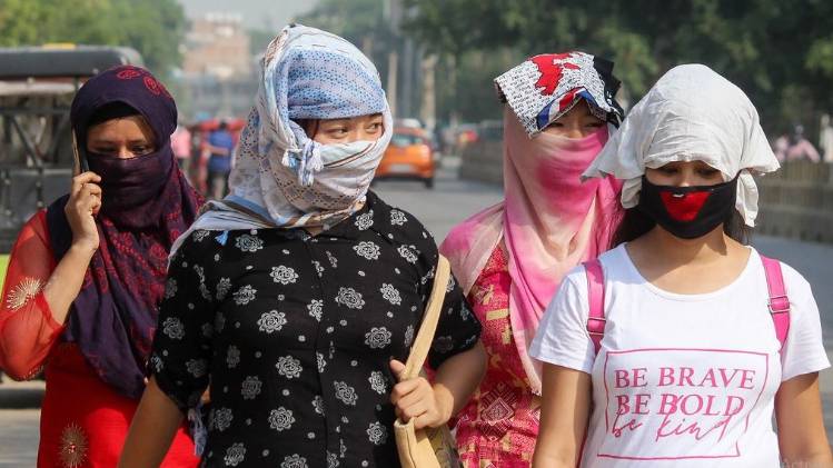 गुरुग्राम में चेहरे को ढककर जाती हुई लड़कियां (फोटो- पीटीआई)