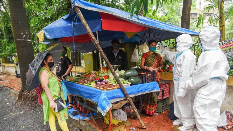 सब्जी बेच रही महिला का तापमान चेक करते स्वास्थ्यकर्मी (फोटो-पीटीआई)