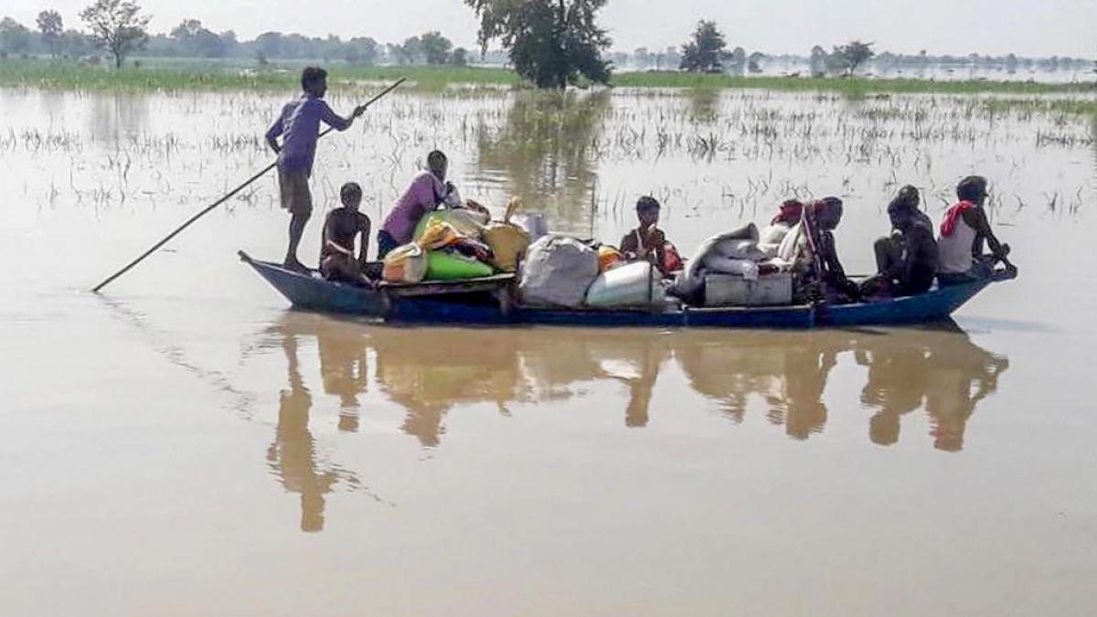 गोपालगंज में सुरक्षित ठिकानों पर जाते बाढ़ प्रभावित लोग (फोटो-पीटीआई)