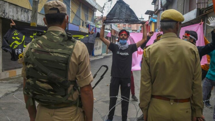 श्रीनगर में मोहर्रम जुलूस निकाल रहे शख्स को रोकने की कोशिश करती पुलिस (PTI)
