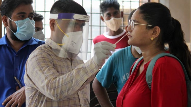 कोरोना टेस्ट करता कर्मचारी