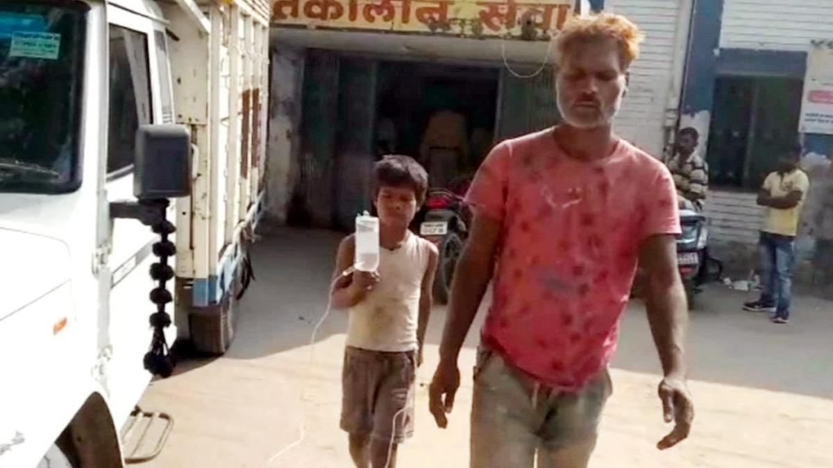 घायल पिता को लगाई गई सलाइन की बोतल लेकर घूम रहा है पांच साल का बेटा.