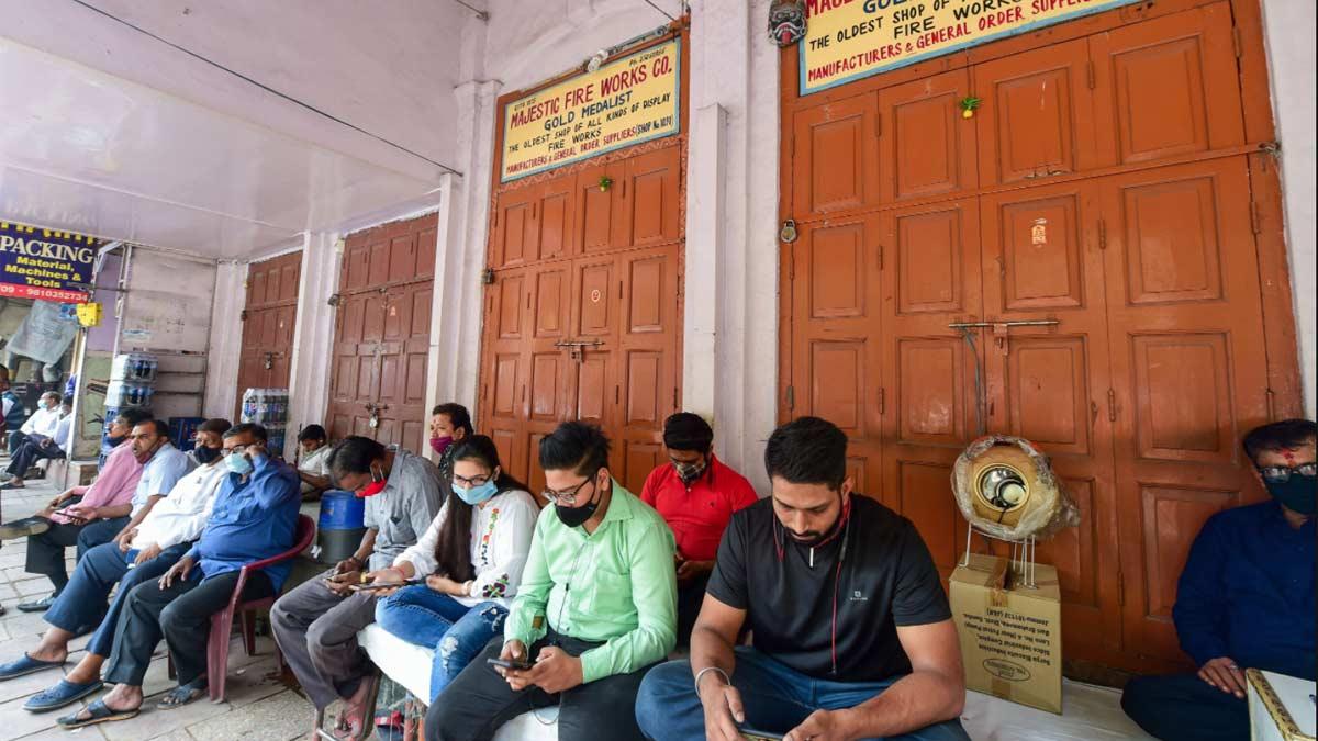 दिल्ली में पटाखों की बिक्री पर रोक लगाए जाने के बाद दुकान के बाहर बैठे दुकानदार (पीटीआई)